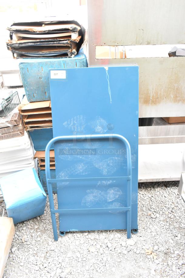Brand new blue metal flat cart, minor scratches and dents, sturdy frame, ideal for transporting heavy items. Label: "227".