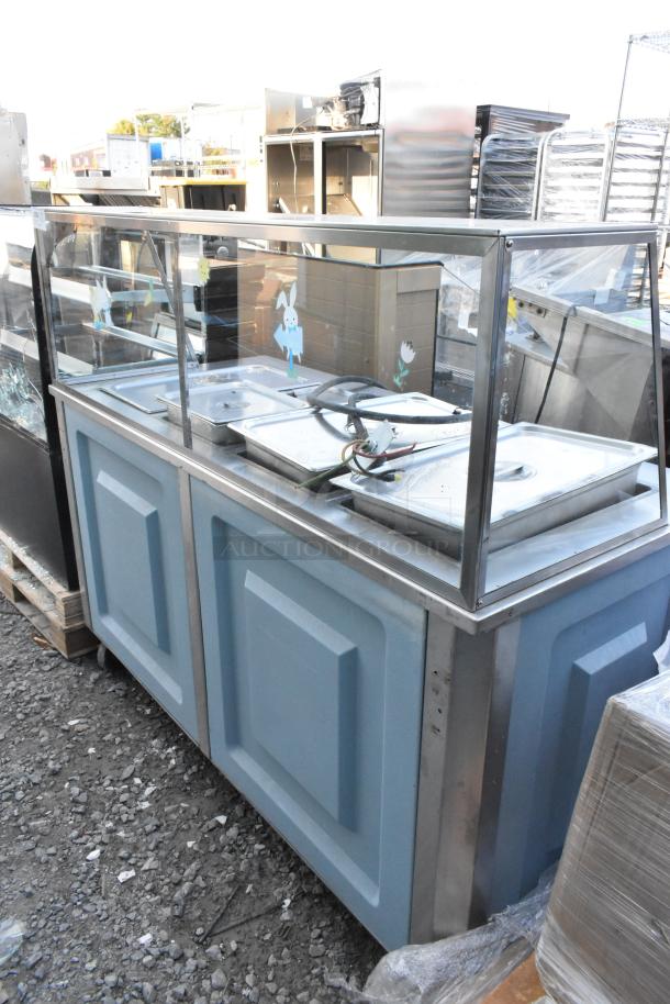 Metal buffet station with sneeze guard, blue panels, three bain-marie pans, slightly worn condition, on pallets.