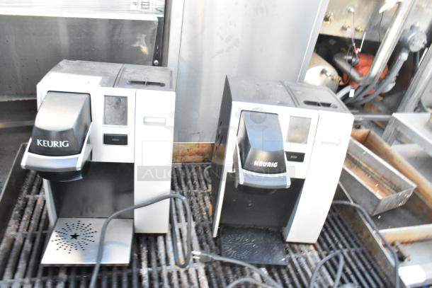 Two Keurig single cup coffee machines, countertop models, 120 volts, 1 phase, used condition, visible power cords.