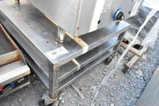 Stainless steel equipment stand with two under shelves on commercial casters, visible wear and rust, tag reads "237 QTY 1".