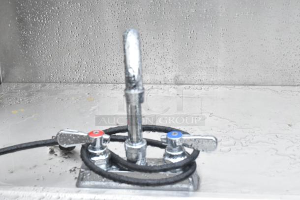 QualServ stainless steel portable sink with commercial casters, water-stained surface, dual faucet controls, robust design.