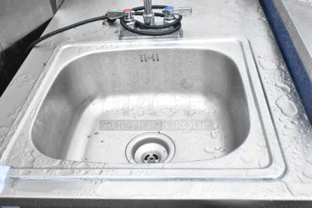 QualServ stainless steel portable sink on commercial casters, wet surface, chrome faucet with dual temp controls.