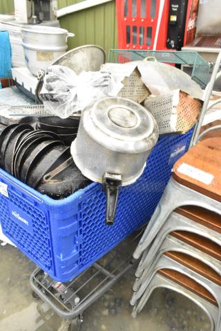 Lot of various items including potato ricer, metal skillets, baskets in a blue crate. Condition appears used. Shopping cart not included.