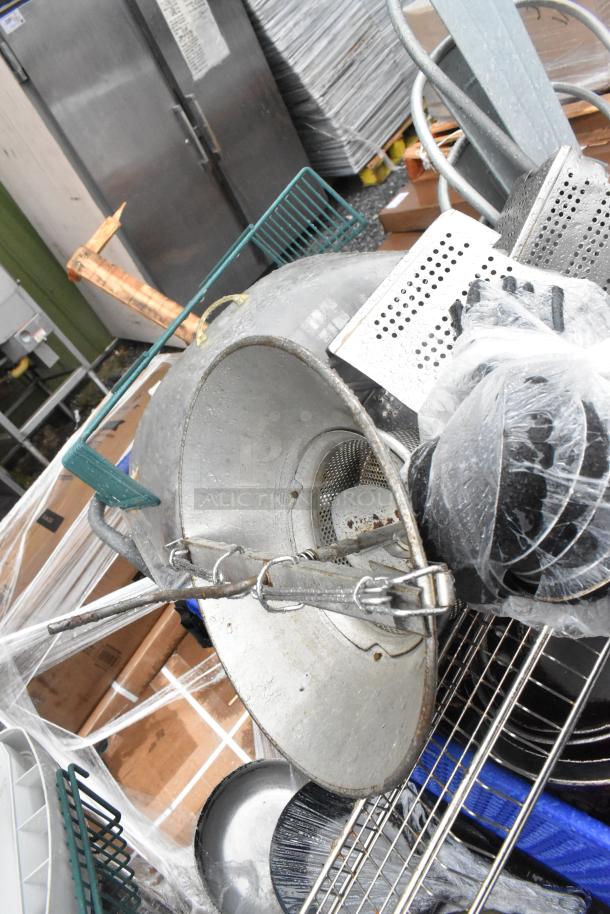 Lot of various kitchen items including a potato ricer, metal skillets, and baskets. Good condition. No shopping cart included.