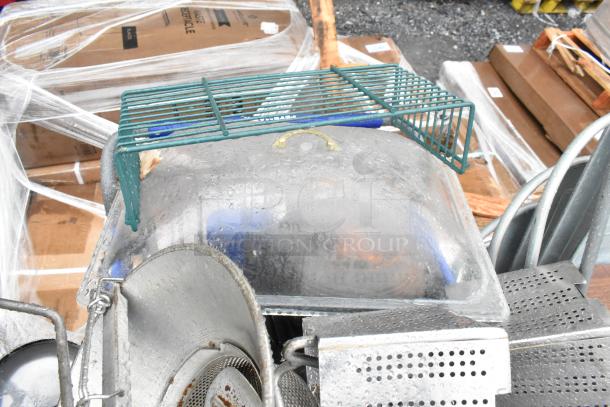 Lot of various items including a potato ricer, metal skillets, and baskets. Note: shopping cart not included.