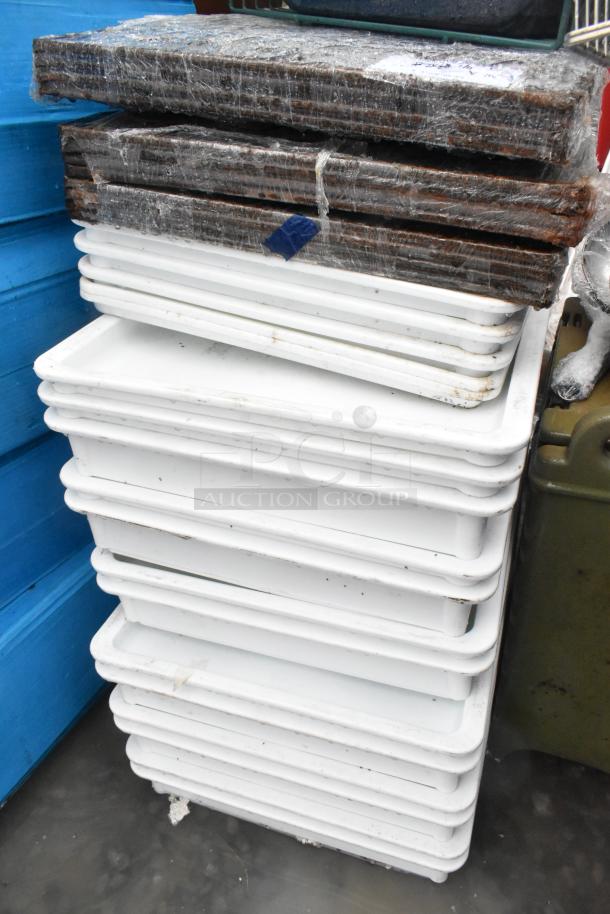 Lot of poly white dough bins and metal baking pans, stacked, varying conditions. Plastic wrap and tape visible on pans.
