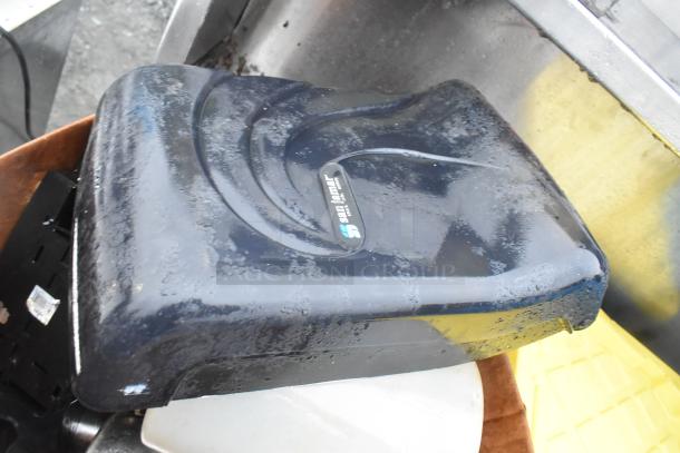 Lot of various items featuring a black San Jamar napkin dispenser. Used condition, visible wear on surface.