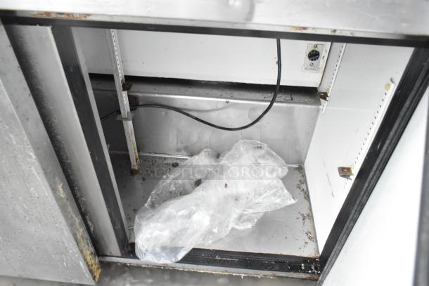 True TSSU-72-18 prep table interior view, showing stainless steel condition, some rust, and wiring. 115V, 1 phase.