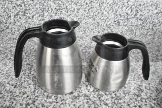 15 metal pitchers with black handles, varied designs, light wear, some with labeling, ideal for multipurpose use.