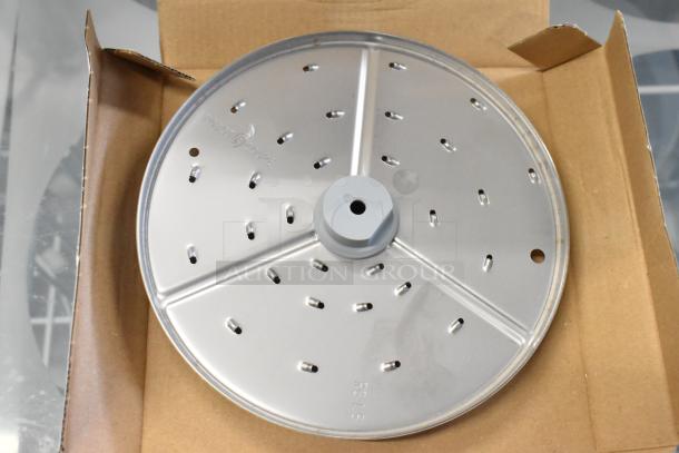 Robot Coupe 27588 grater blade in gray condition, features multiple perforations, secured in packaging, branded markings visible.