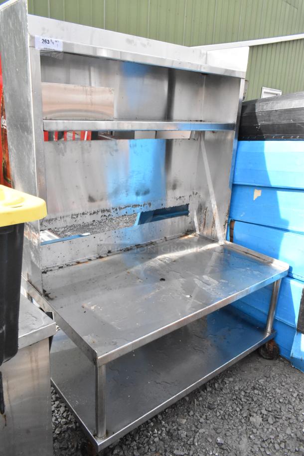 Stainless steel equipment stand with over shelves, under shelf, on commercial casters; shows wear, number tag 263.