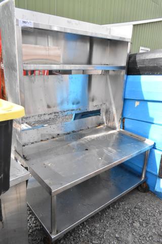 Stainless steel equipment stand with over shelves, under shelf, on commercial casters; shows wear, number tag 263.