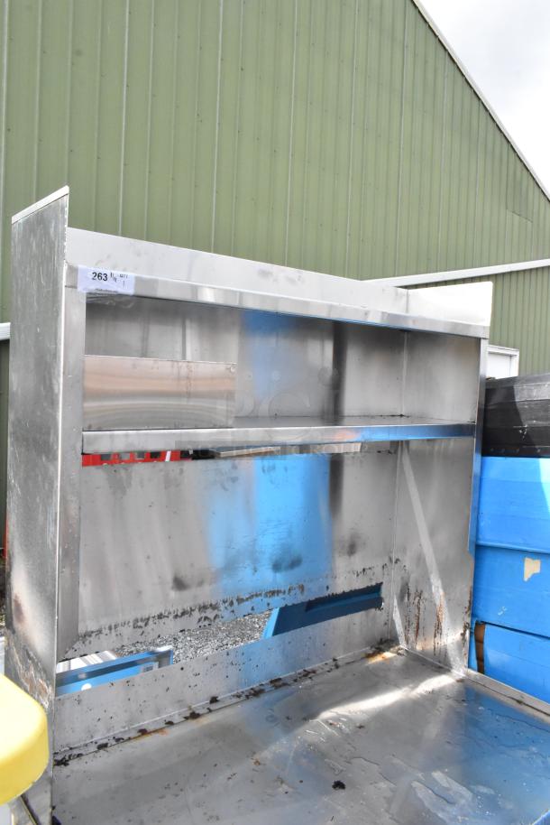 Stainless steel equipment stand with over shelves, under shelf, and commercial casters. Shows signs of wear and surface rust. Tag labeled "263".