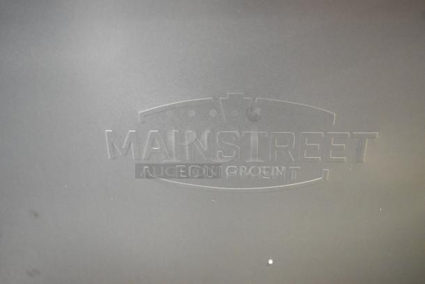 Mainstreet Equipment logo embossed on stainless steel surface.