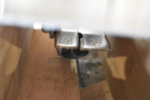 Close-up of a stainless steel on/off switch mechanism, part of Avantco 178CBE52HC chef base.