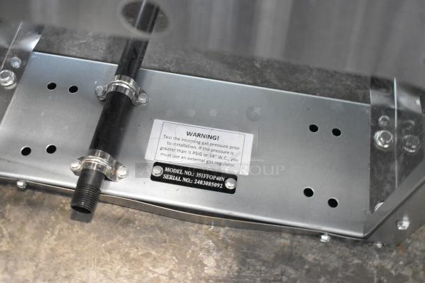 Stainless steel base of Cooking Performance Group 351FFOP40N fryer. Warning label for gas pressure. Model and serial number plate visible.