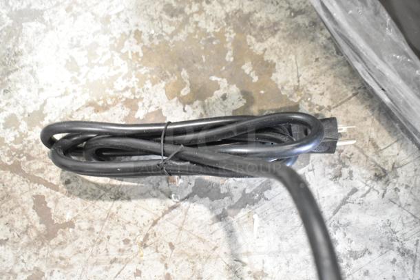 Coiled black power cord for Avantco 177EG24N griddle on concrete floor. Electric plug visible.