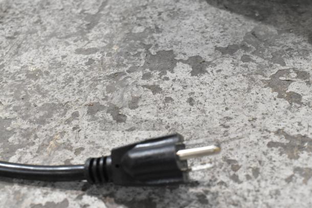 Black power plug on a textured surface, part of a Carnival King Jetcof 480M beverage dispenser, 115 Volts, 1 Phase.