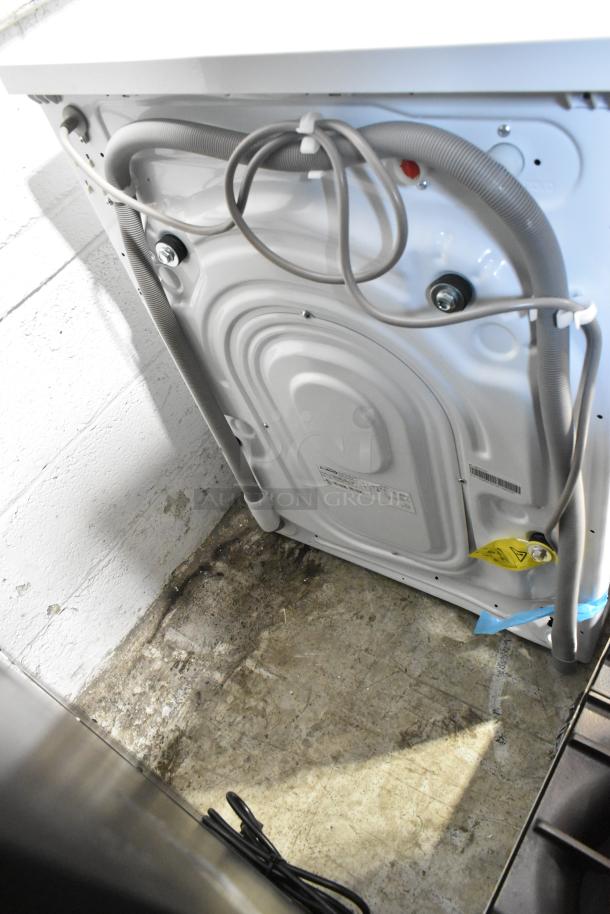 Rear view of a new KoolMore FLC-3CWH 2.7 cu. ft. washer-dryer combo, showing hoses and electrical components.