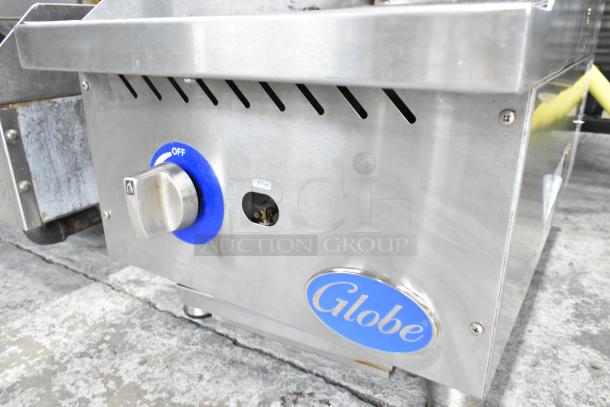 Globe stainless steel commercial countertop gas charbroiler grill with control knob, logo, and vent openings, in good condition.