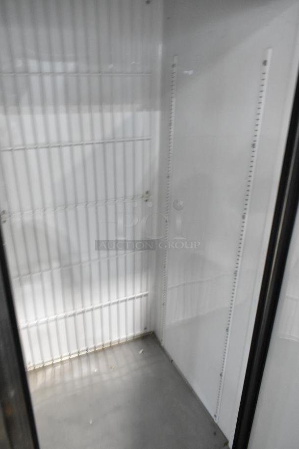 True T-49F stainless steel commercial 2-door reach-in freezer interior with poly coated racks, on commercial casters.