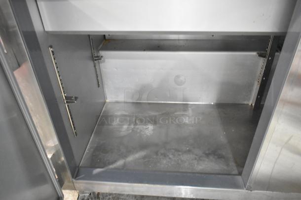 Leader ESLM60S/C stainless steel commercial prep table, interior view. Features adjustable shelving, visible wear. 115V, 1 phase.