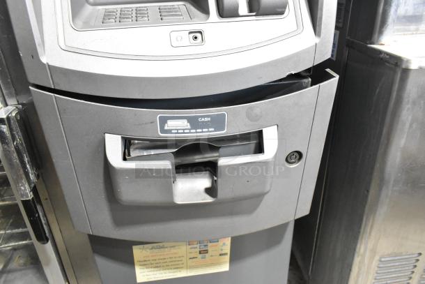 Hyosung metal floor-style ATM, keypad and cash slot visible, good condition, fee and service stickers attached.