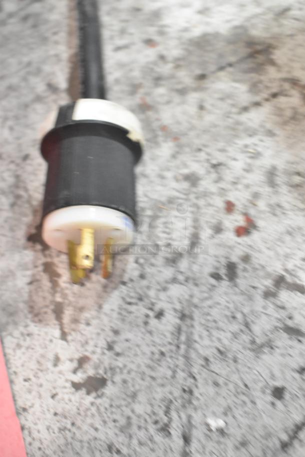Close-up of the power plug for a Taylor 441-27 soft serve ice cream machine on a textured surface.