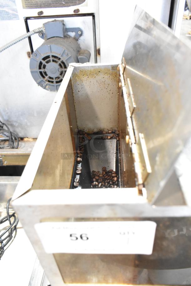 Metal commercial countertop coffee bean grinder, 120 volts, 1 phase, used condition, showing interior with coffee beans.