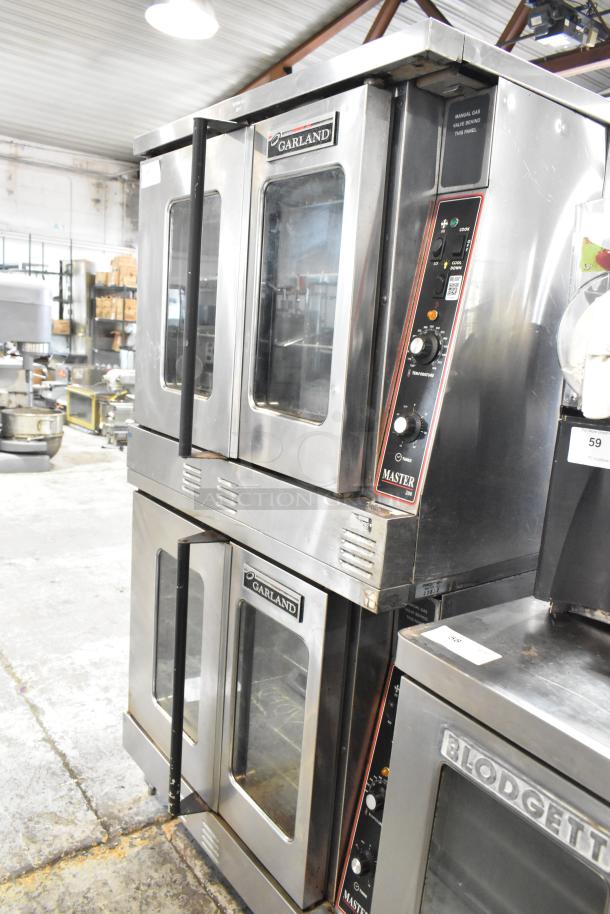 2 Garland Master 200 stainless steel convection ovens with view-through doors, metal racks, and thermostatic controls; commercial use.