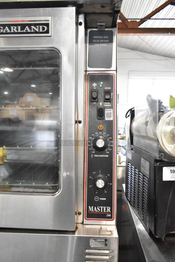 2 Garland Master 200 stainless steel commercial convection ovens with view-through doors, metal racks, and thermostatic controls.