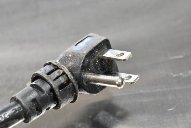 Close-up of a power plug for the Everest ETF1 stainless steel commercial undercounter freezer, showing prongs and black casing.