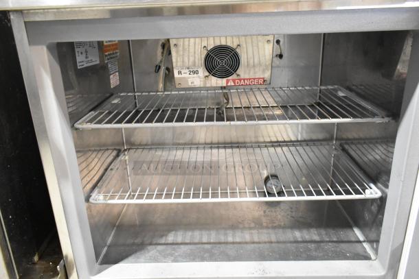 2020 Delfield 18MC32P-BI stainless steel prep table interior with shelving, R-290 refrigerant unit, and temperature gauge.