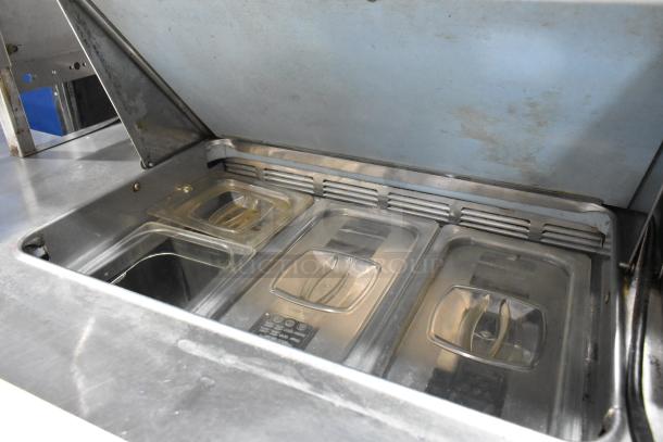 Delfield stainless steel commercial sandwich salad prep table. Features four drawers, mega top, and bain marie containers.