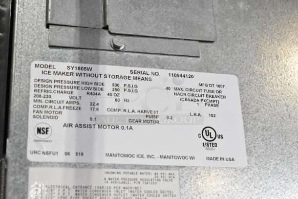 Manitowoc SY1805W stainless steel commercial ice head, 208-230 volts, 1 phase, on ice bin. Label shows model and specs.
