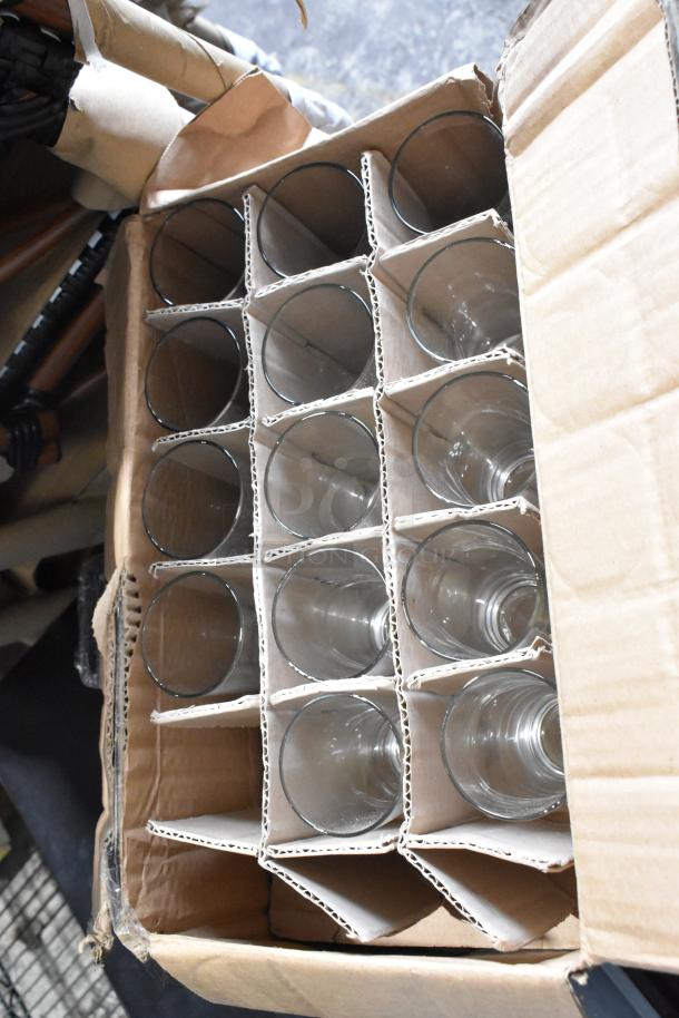 Box of new glassware including G.E.T. 9910-1-BL Bahama 10 oz. blue tumblers and Libbey 133 9 oz. highball glasses.