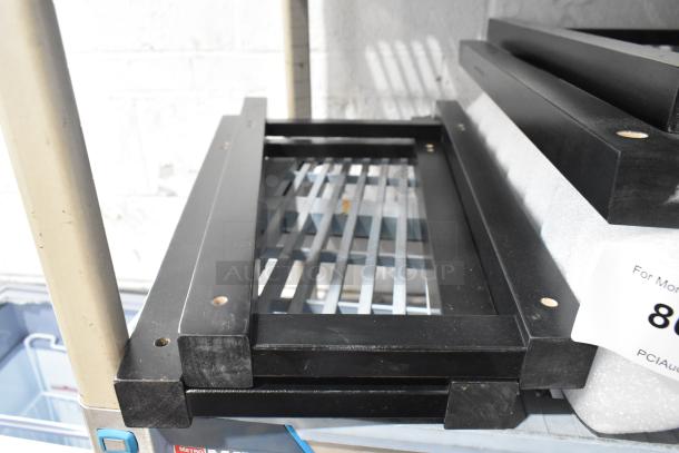 Lot of black wooden pieces, brand new but labeled "scratch and dent," showing some minor wear.