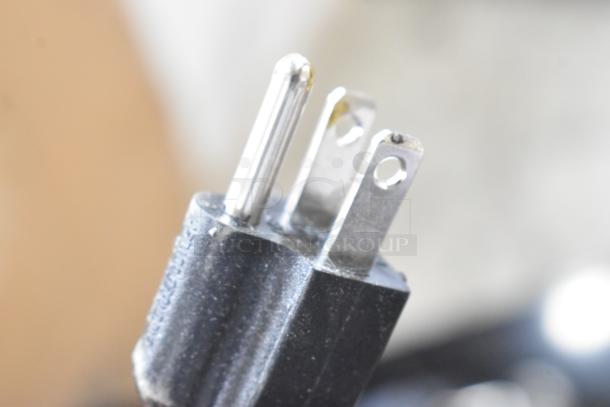 Power plug of 2024 Canarm 664XFS20 exhaust fan, showing two flat prongs and one round prong, indicating 115V compatibility.