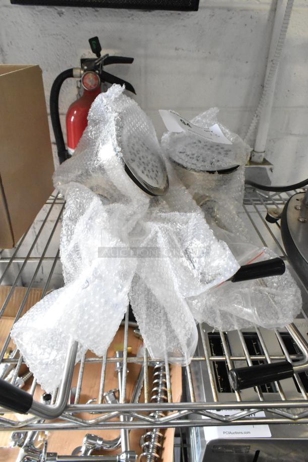 Three new showerheads wrapped in bubble wrap, labeled "Scratch and Dent," on a metal shelf.
