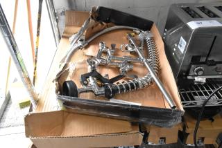 Brand new spray nozzle attachment with scratches and dents, chrome finish, visible components, in torn box.