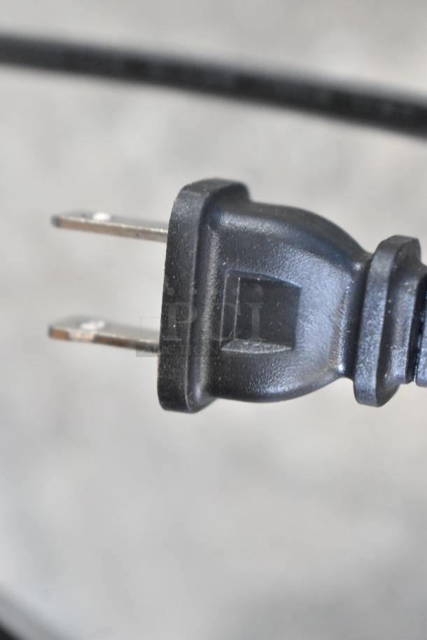 Close-up of a power plug from a Proctor Silex 43672PS 12 Cup Programmable Drip Coffee Maker. Black two-prong design.