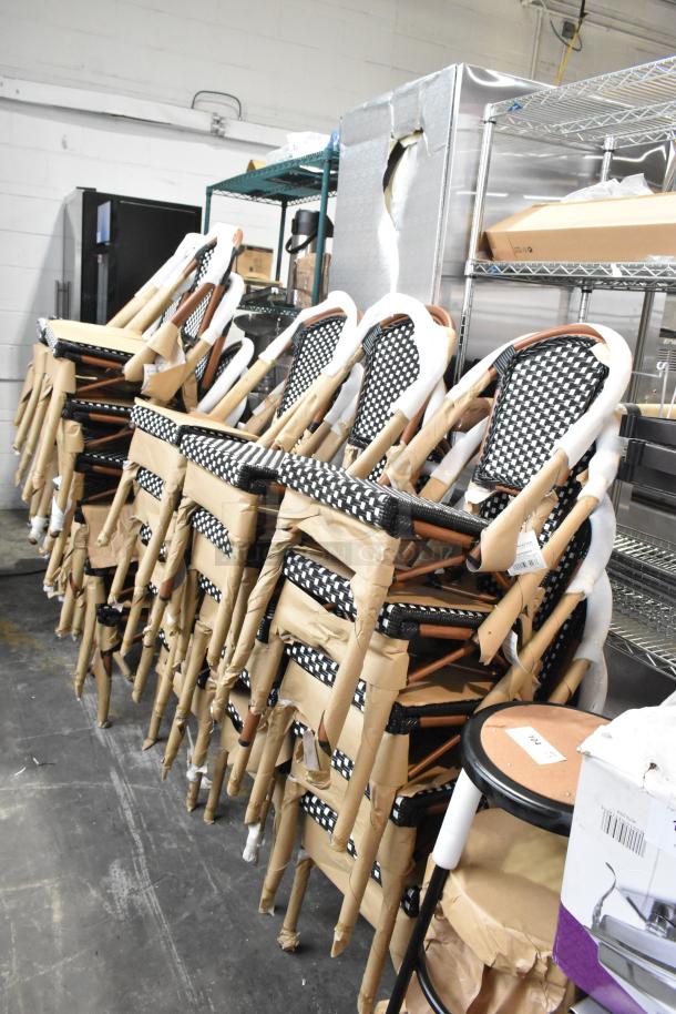 33 new Lancaster Table & Seating 427CSRTBSBKW bistro chairs, black/white rattan, scratch and dent condition, stacked.