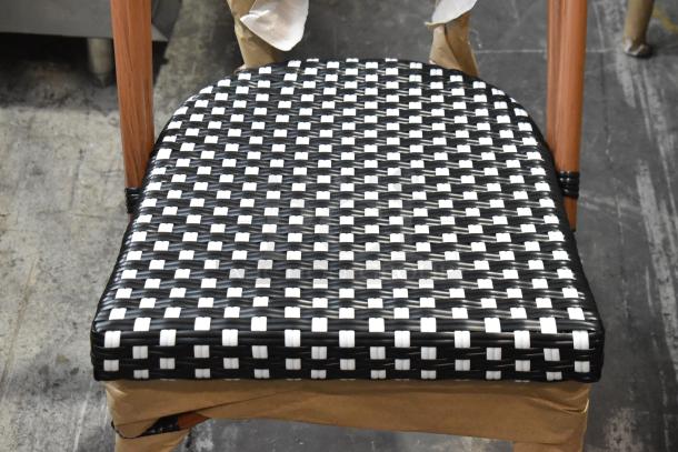 Brand new Lancaster Table & Seating bistro chair with black and white checkered rattan weave. Scratch and dent condition.