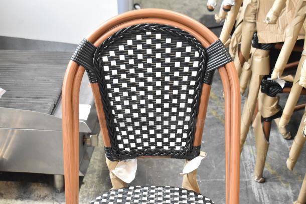 Lancaster Table & Seating black and white checkered rattan outdoor side chair, brand new condition, scratch and dent sale.