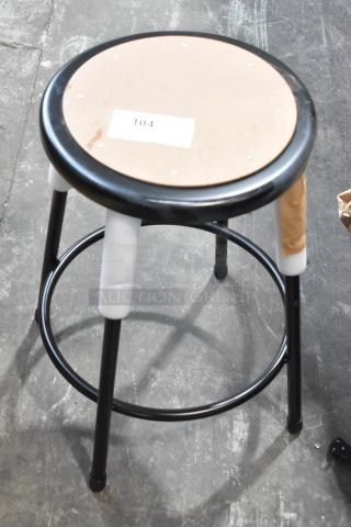 Black metal stool with a round seat. Listed as new with scratch and dent imperfections. Label marked "104" on seat.