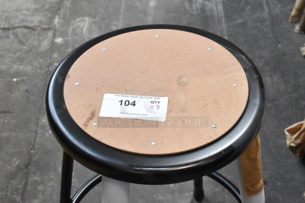 Black metal stool, new, scratch and dent, visible bottom label "104 QTY X3." Durable construction, ideal for auction.
