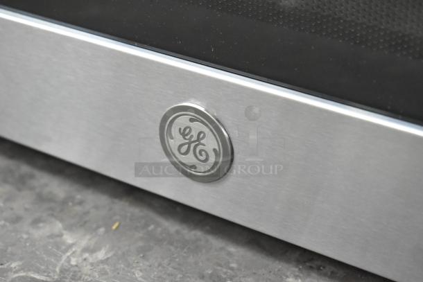 BRAND NEW General Electric GE PCST22U1W1SS Microwave Oven, stainless steel, with manufacturer's logo, minor scratches.