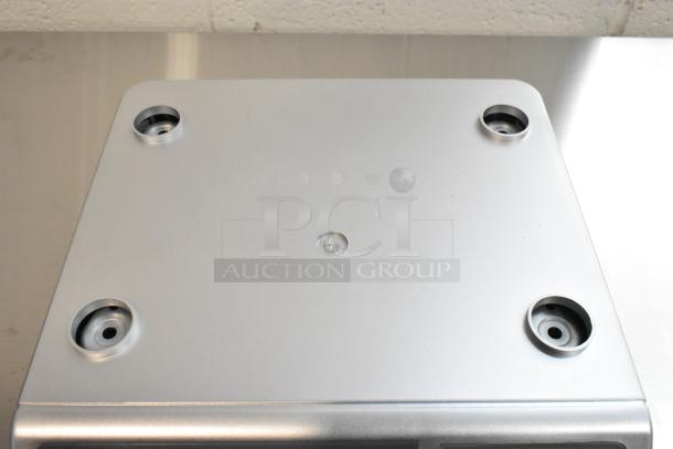 Brand new San Jamar Escali SCDGM66 66 lb. digital portion control scale, showing scratch and dent condition surface.