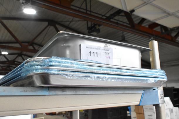 5 new Vigor 24711422 stainless steel hotel pans and Choice 407BUNFULL aluminum bun pans on shelf, labels indicating lot.