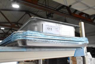 5 new Vigor 24711422 stainless steel hotel pans and Choice 407BUNFULL aluminum bun pans on shelf, labels indicating lot.